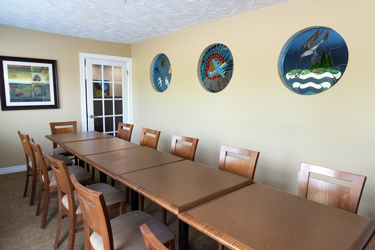 Conference room in Nova Scotia with a long meeting table, decorative art, and natural lighting.