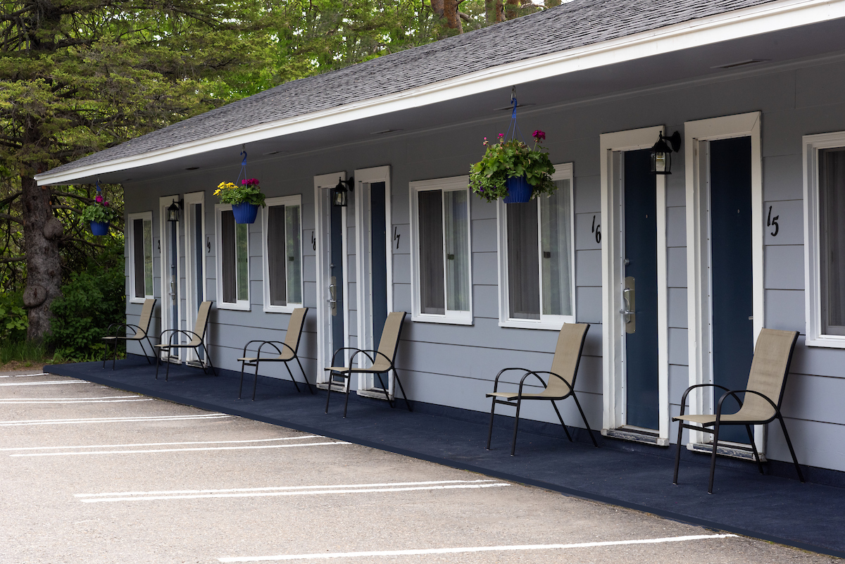 Exterior view of Aurora Inn, a picturesque Annapolis Valley motel with outdoor seating and flower baskets.